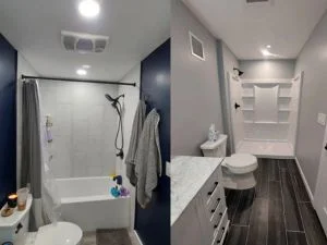 Bathroom with navy painted walls, white vanity, dark tile flooring, and glass shower enclosure
