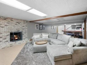Gray painted living room with fireplace, recessed lighting, and neutral furnishings