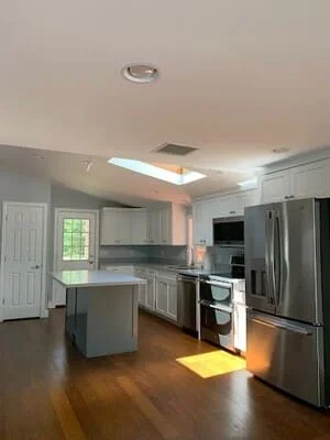 Kitchen remodel with gray cabinetry, stainless steel appliances, island, and hardwood floors