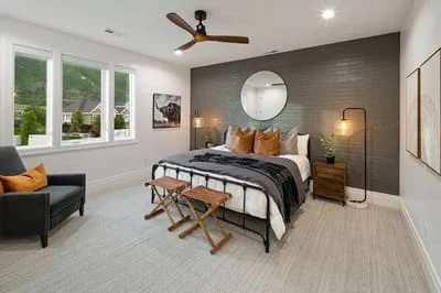 Master bedroom with gray brick accent wall, white shiplap, and light wood flooring